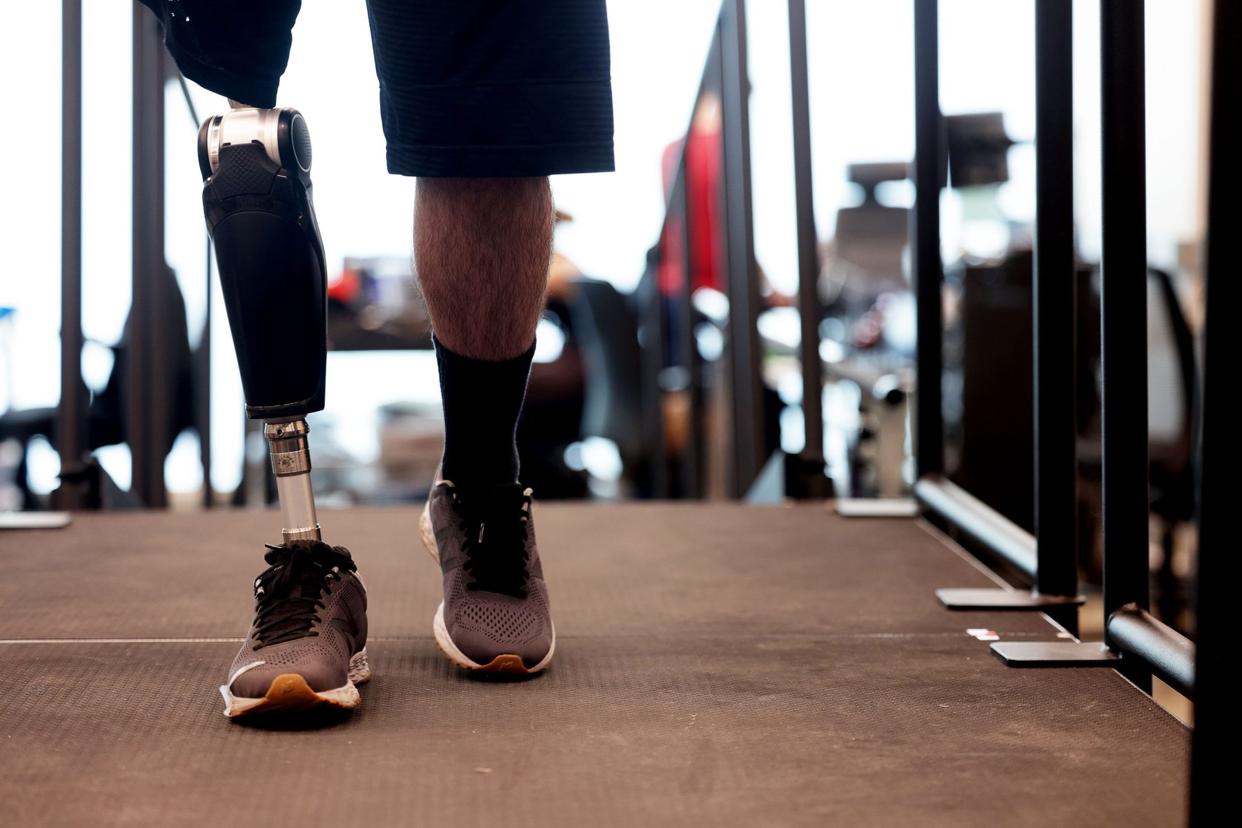 A person walking on a treadmill with a powered knee prosthesis.
